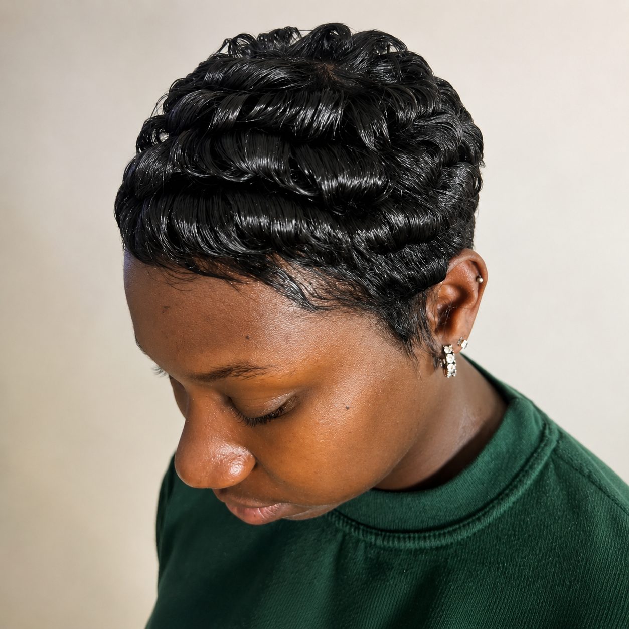 Top-down view of glossy finger waves on a freshly refreshed pixie cut
